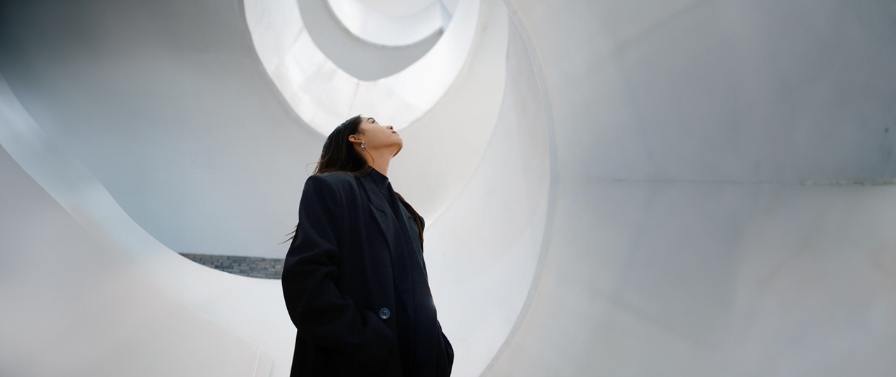 A girl sitting beside a wall reading investment themes